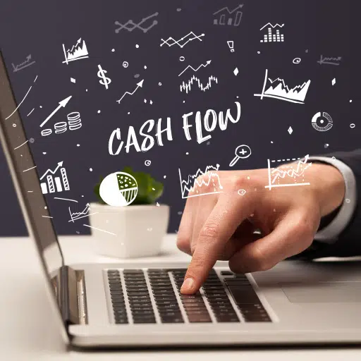 A businessman is using his computer to properly track and manage the cash flow of his business.