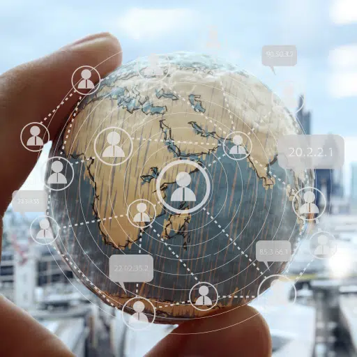 Globalization is represented by fingers holding a globe with interconnected icons overlayed
