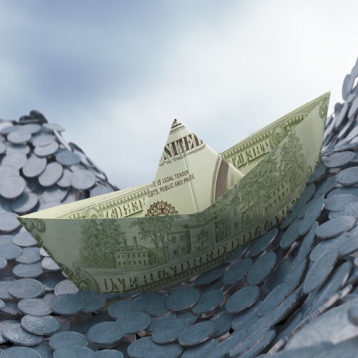 Liquidity management represented by dollar bill, folded like a boat, floating in a sea of coins.