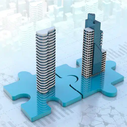 Business mergers and acquisitions represented by two skyscrapers sitting on connecting puzzle pieces.