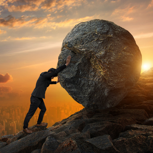 A businessman pushing a boulder uphill meant to represent challenges a property manager must face.