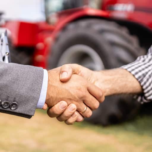 Businessmen shaking hands over an equipment deal.